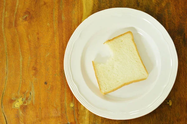 Slice bread bite on white plate — Stock Photo, Image