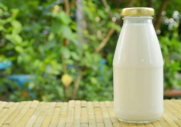 bottle of milk on bamboo mat in park