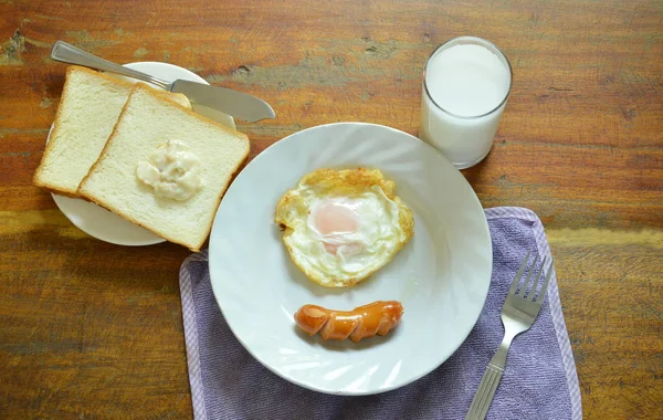 Uovo fritto e salsiccia di maiale con pane mangiare coppia latte colazione set — Foto Stock
