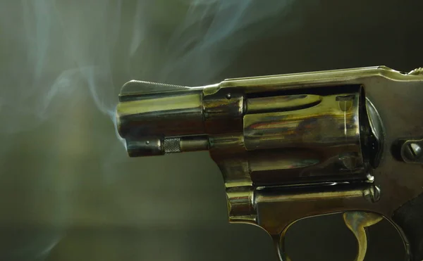 Револьверна гармата з димом, що плаває в повітрі після стрілянини на чорному тлі — стокове фото