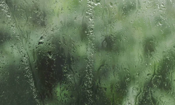 Forma d'acqua su finestra di vetro in giorno piovoso — Foto Stock