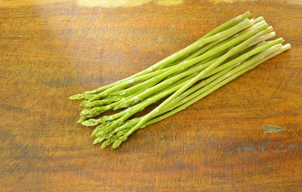 Cibo fresco verde asparagi crudo su tavola di legno — Foto Stock