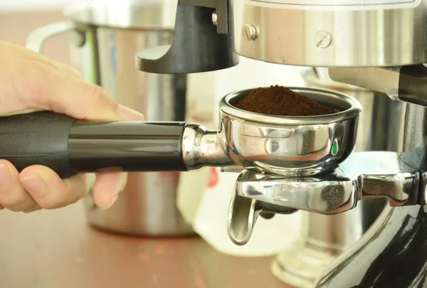 Mão segurando café em pó tiro em copo inoxidável para máquina — Fotografia de Stock