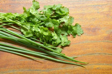  taze maydanoz ve taze soğan ahşap masanın üzerine düzenlenmiş