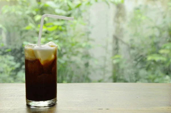 Eiskaffee-Topping Milch schwimmend mit Stroh im Glas — Stockfoto
