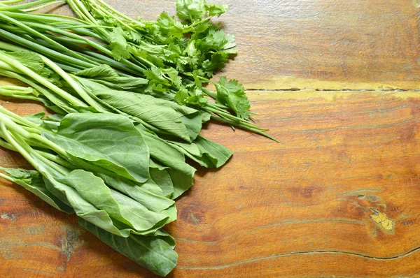 Сорт свежих зеленых овощей на деревянном столе — стоковое фото