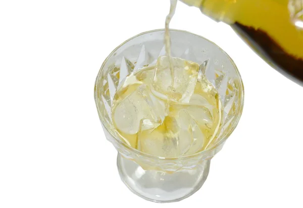 Uísque derramado de garrafa no gelo em fundo branco — Fotografia de Stock