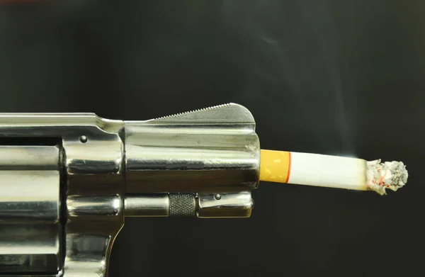 Τσιγάρο φωτιά στο όπλο ρύγχος σε σύγκριση με το κάπνισμα να σκοτώνει — Φωτογραφία Αρχείου