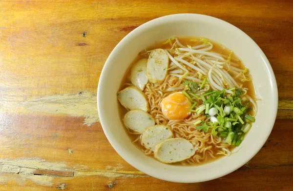 Kokt instant noodle toppning ägg äggula och skiva fisk linje i kryddig soppa — Stockfoto