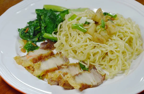 Fideos de huevo chinos rematando cerdo crujiente en el plato — Foto de Stock