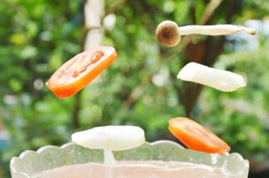  domates ve soğan ile cam kase su mantar düşüyor