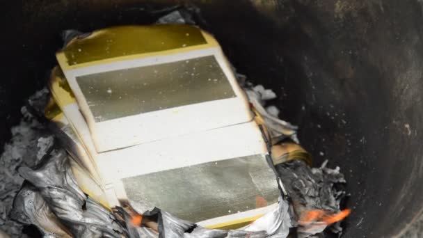 Oro y papel de plata ardiendo para ofrecer ancestros en cuenca de hierro — Vídeos de Stock