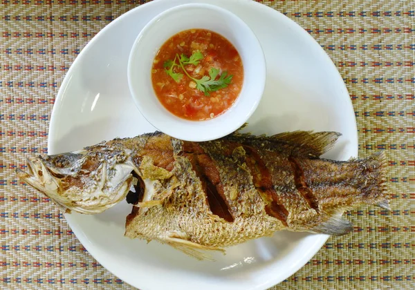 Глибоко обсмажена басова риба занурює гострий і кислий соус на тарілці — стокове фото