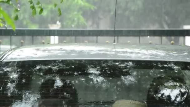 Heavy rain falling and water splashing on roof car in parking — Stock Video
