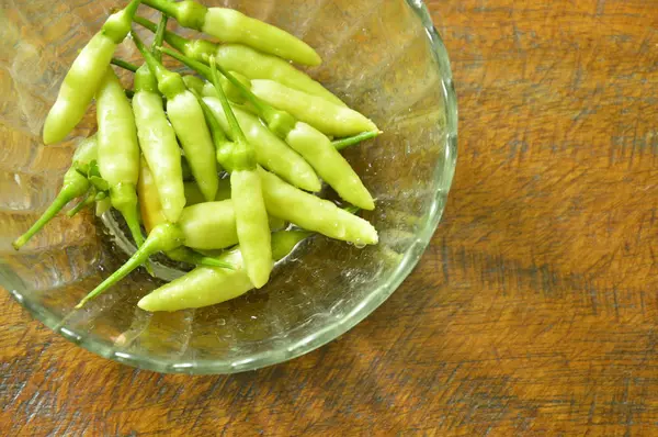 Fresh green chili with drop of water on glass cup — Stock Photo, Image