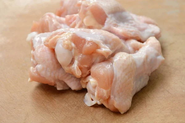 Rå kyckling trumpinnar på trä chop block — Stockfoto