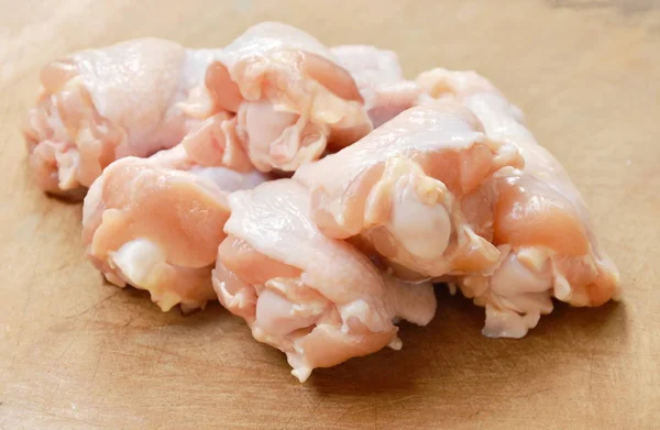 Rå kyckling trumpinnar på trä huggkubben — Stockfoto