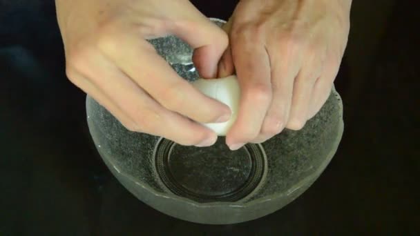 Guscio d'uovo bianco incrinato a mano in una ciotola di vetro sulla cucina — Video Stock