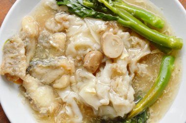  kızarmış pirinç noodle bas balık ve Çince lahana ile plaka üzerinde et suyu sosu ilave edin