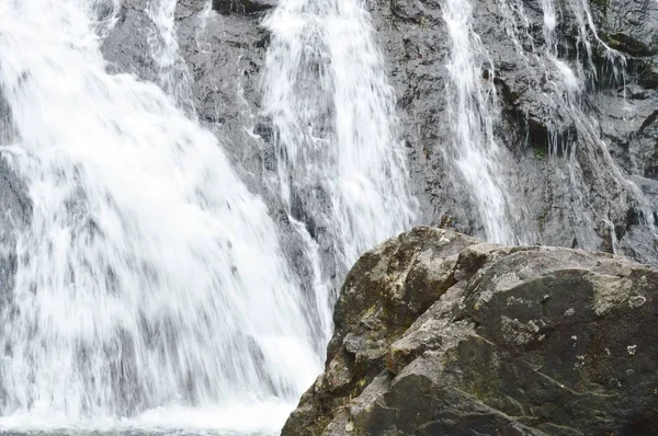Cachoeira caindo e atingiu rocha espirrando para o rio — Fotografia de Stock