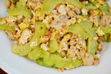  Kızarmış acı salatalık kıyılmış domuz eti ile karıştırın ve plaka üzerinde yumurta