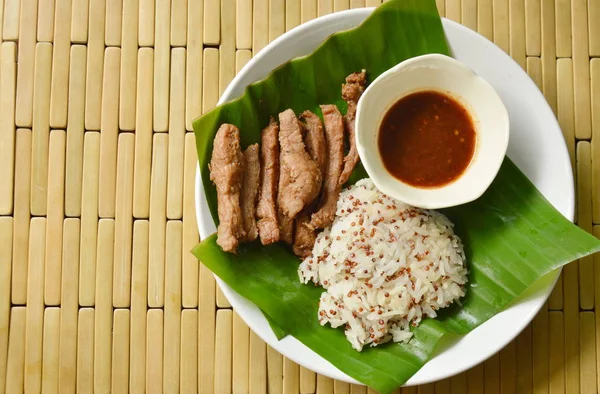 Arroz pegajoso de quinua comer pareja con tiras de cerdo salado y salsa salada en hoja de plátano fresco —  Fotos de Stock