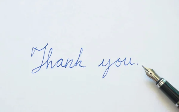 Füllfederhalter schreiben Dankeswort auf weißem Hintergrund — Stockfoto