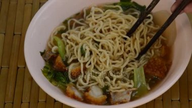 Çin erişte çorbası tarafından ahşap çubuk toplama gevrek domuz tepesi yumurta