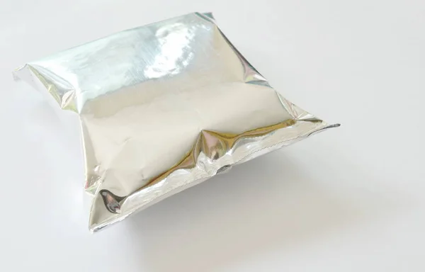 Paket beyaz zemin üzerine alüminyum folyo içinde snack — Stok fotoğraf