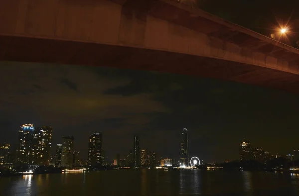 Мост и строительный ландшафт на реке ночью — стоковое фото