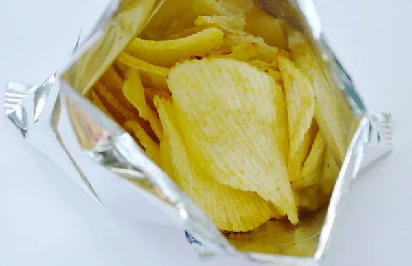 Kartoffelchips in Alufolie-Verpackung auf weißem Hintergrund — Stockfoto