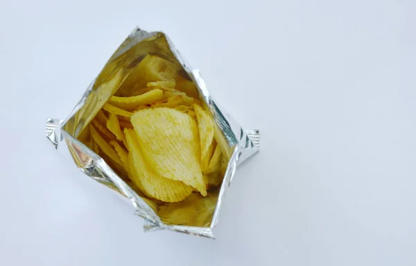 Kartoffelchips in Alufolie-Verpackung auf weißem Hintergrund — Stockfoto