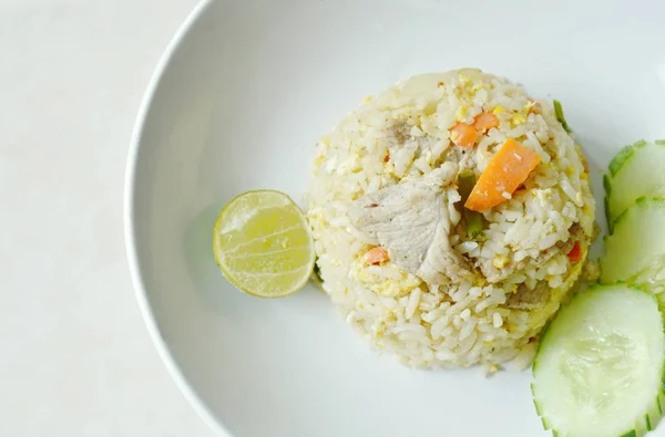Smažená rýže s vepřovým a plátek citronu na desce — Stock fotografie