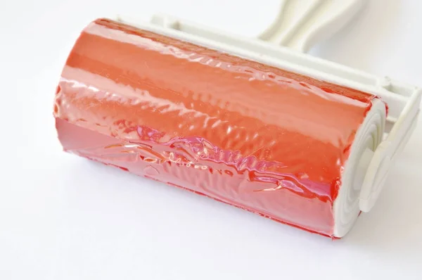 Rullo di polvere appiccicoso rosso su sfondo bianco — Foto Stock