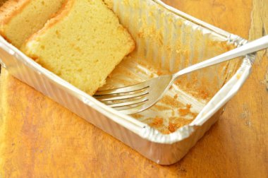  tereyağı pasta dilimi ve gümüş çatal Aluminyum Tepsi içinde