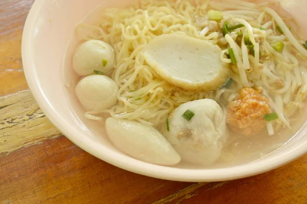 Macarrão chinês ovo topo bolinho de peixe e bola de camarão em sopa clara na tigela — Fotografia de Stock