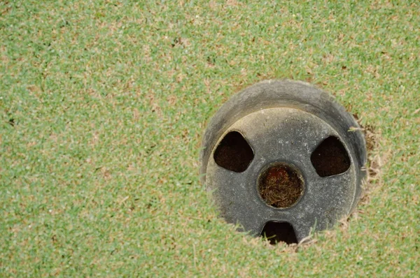 Lyuk a zöld golf bíróság mezője napsütéses napon — Stock Fotó