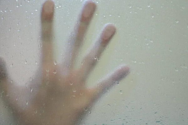 Hand touching on glass bathroom door — Stock Photo, Image