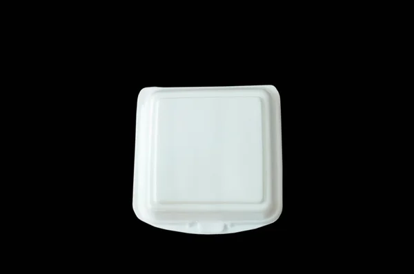 白い泡のボックスに黒の背景の上に食べ物が含まれています — ストック写真
