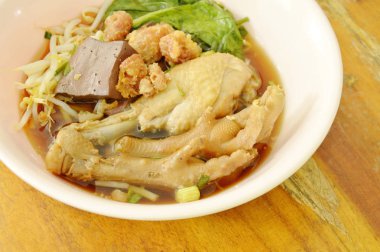  Haşlanmış tavuk budu ve ayakla fasulye filizi kahverengi bir çorba kasesinde.