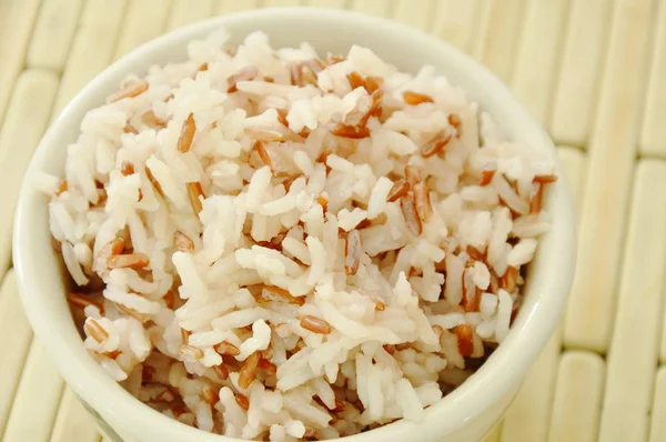 Красный рис в чашке на бамбуковой тарелке — стоковое фото