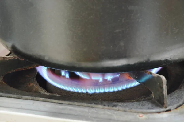 Black pot boiled on fire gas stove in kitchen — Stock Photo, Image