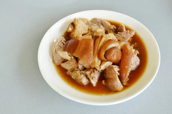 Coscia di maiale brasata con fetta di zuppa di erbe nere cinesi sul piatto — Foto Stock