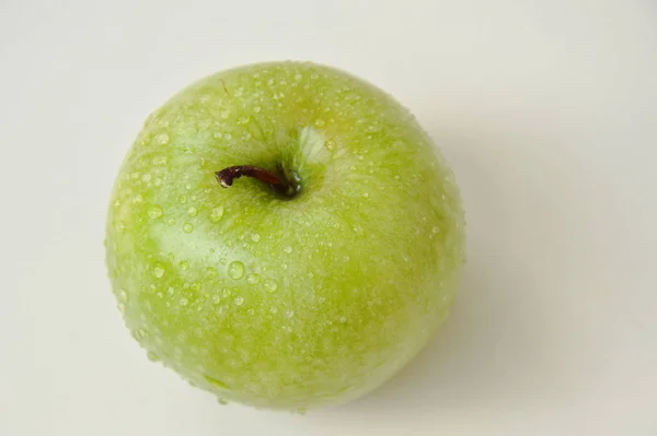 Grüner Apfel mit Wassertropfen auf Fliesenhintergrund — Stockfoto