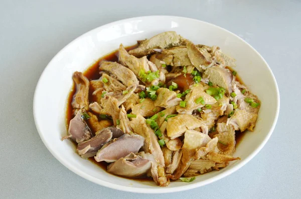 Bebek rebus dalam irisan sup coklat dan topping chop bawang di piring — Stok Foto
