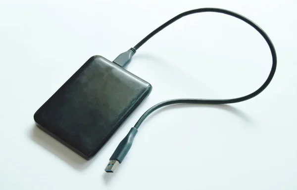 Black universal serial bus external hard disk connecting to computer on white background — Stock Photo, Image