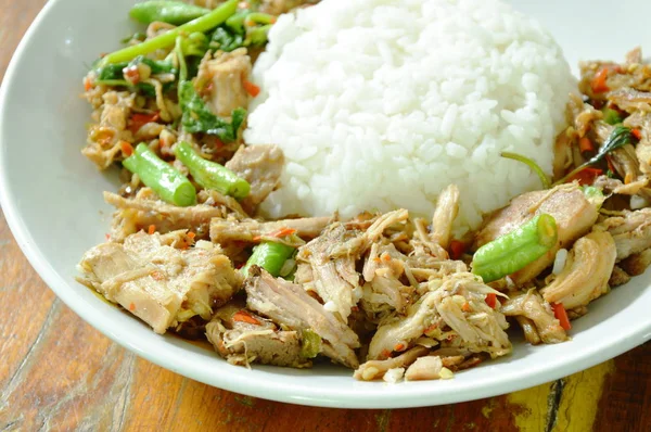 Pedas aduk goreng kaki babi direbus dengan daun kemangi dan nasi di piring — Stok Foto