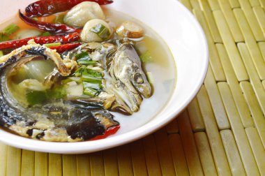  Baharatlı ve ekşi çorba kase üzerinde füme kuru yılan kafa balık haşlanmış