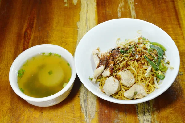 Macarrão amarelo chinês seco que cobre a carne de porco de fatia e bola que veste o molho de soja preto doce com sopa — Fotografia de Stock