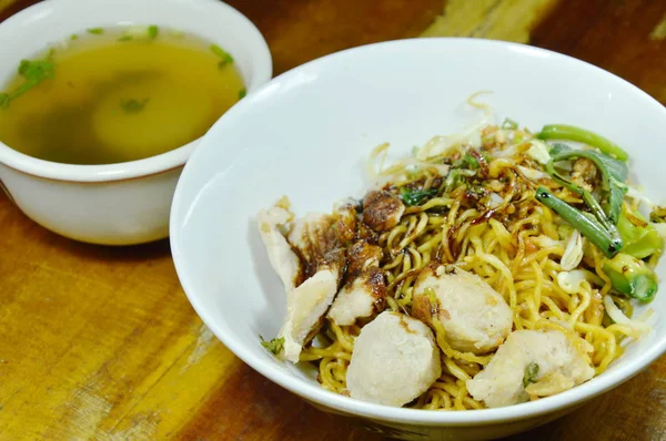 Macarrão amarelo chinês seco que cobre a carne de porco de fatia e bola que veste o molho de soja preto doce com sopa — Fotografia de Stock